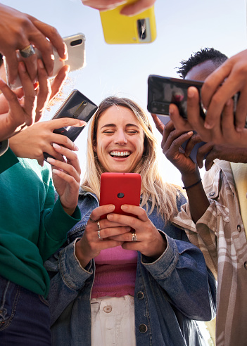 Group of friends and family using cell phones together to contribute